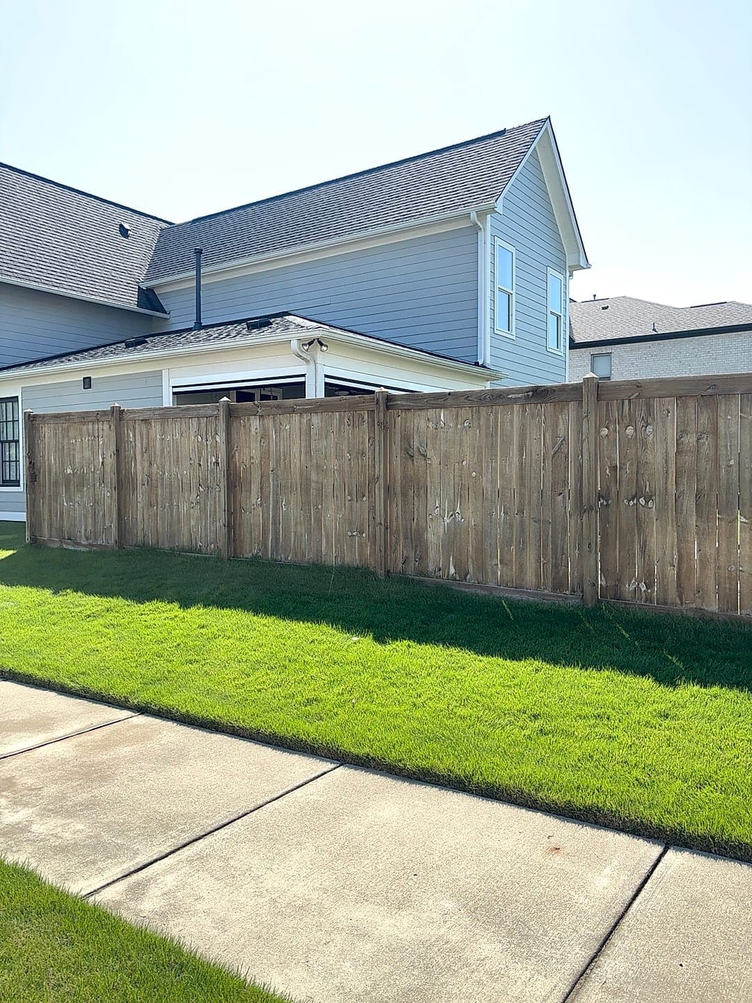 Brightened wood fence and siding after cleaning