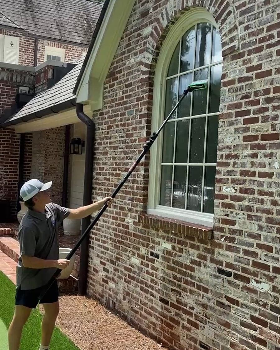 Bluestone Pro Wash crew cleaning an arched window with a water-fed pole